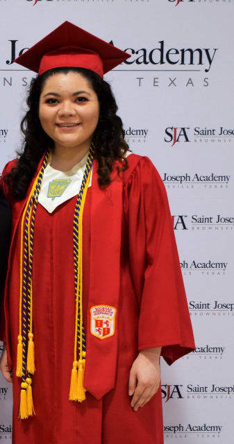 diana stands wearing her red graduation gown and cap