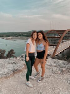 Cagla and her sister pose in front of blue sky and scenery of 360 Bridge Overlook in Austin. 
