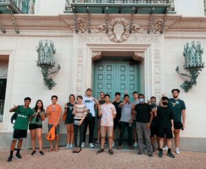 students pose outside a library on the UT Austin Campus