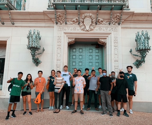 International students stand in front of UT library doors during a campus tour