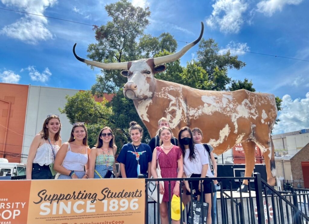 International students stand in front of a Texas Longhorn sculpture during an ISSS orientation activity