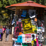 A kiosk on UT campus holds many colorful flyers advertising student events.