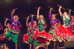 Dance crew performs traditional Indian dance on stage. 