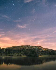 Enchanted Rock, a large desert landmark, at dusk with stars above. 