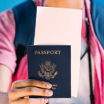 a traveler holds a passport in front of him