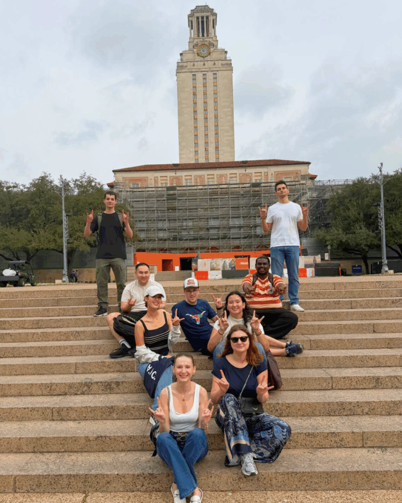 Students sitting together along the steps in front of the UT Tower