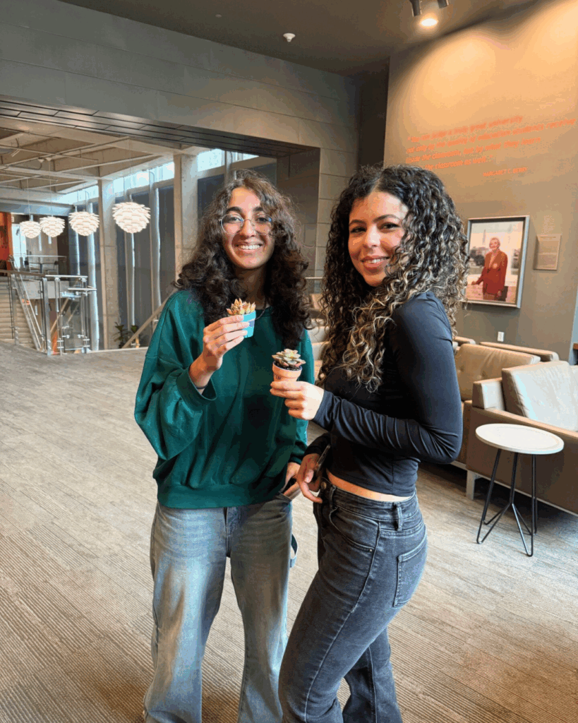 Two students together with small plants and plant pots in their hands
