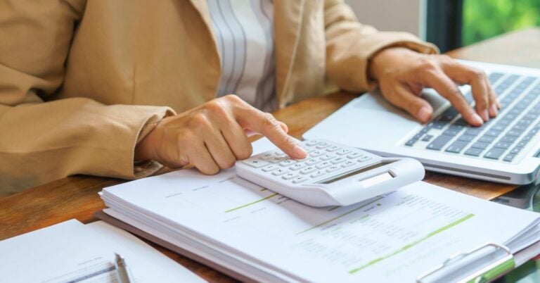 Accountant using a laptop and calculator