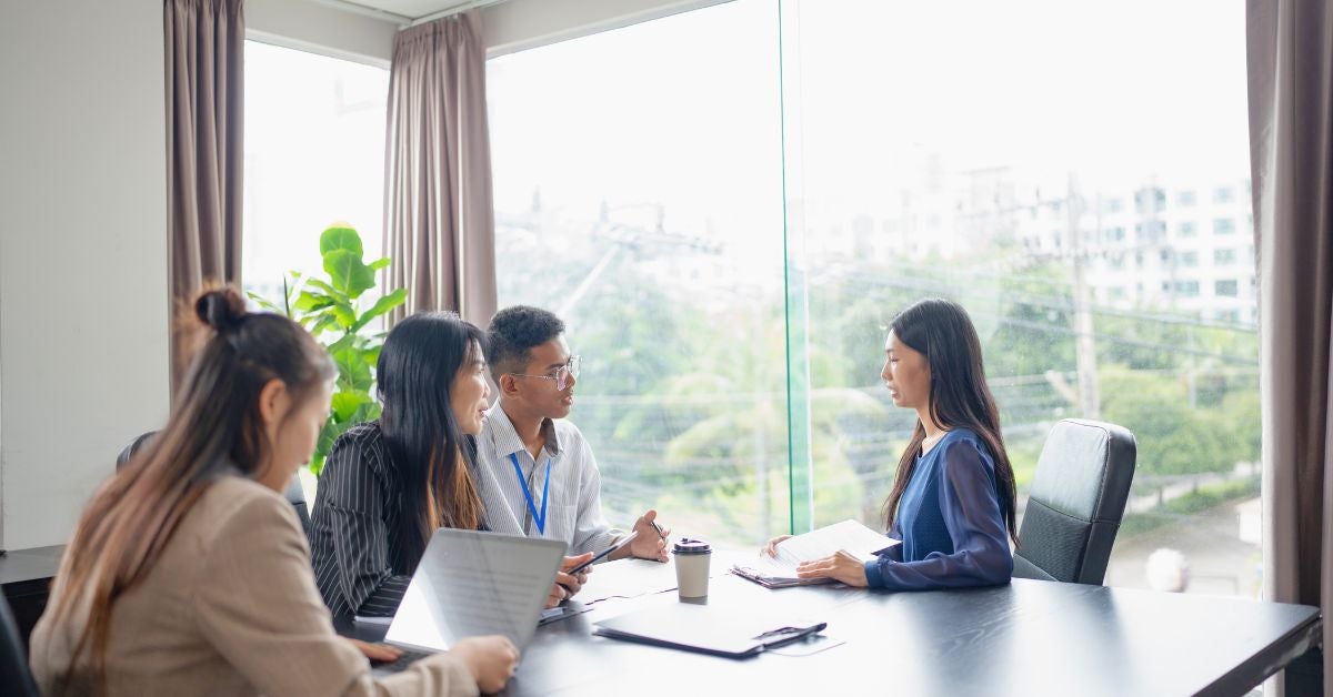 A woman being interviewed by three people for a new job position. 
