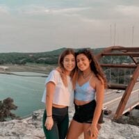 Cagla and her sister pose in front of blue sky and scenery of 360 Bridge Overlook in Austin.
