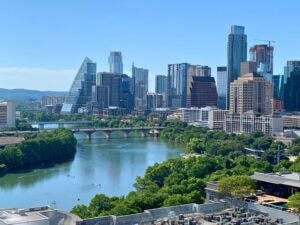 Austin skyline with modern skyscrapers along the River under a clear blue sky.