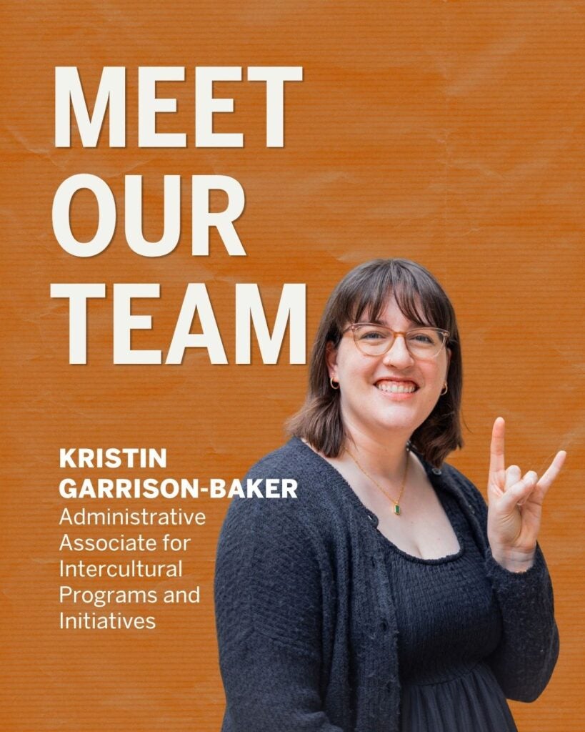 Smiling woman with glasses and dark hair making a hand gesture against an orange background with 'Meet Our Team' text.